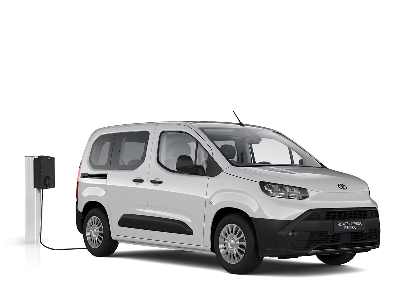 Weißer Proace City Verso Electric Comfort steht vor neutralem Hintergrund neben einer Ladesäule.