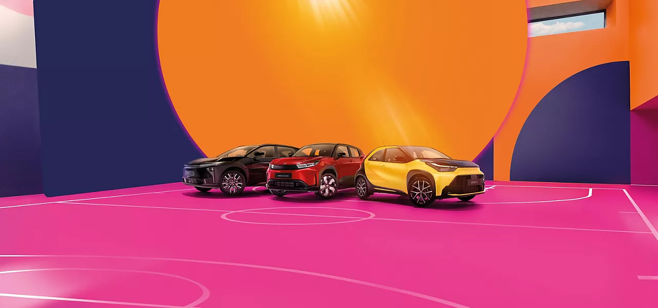Aygo X, Yaris Cross und C-HR auf einer bunten Backplate, die einen Basketballplatz darstellen.
